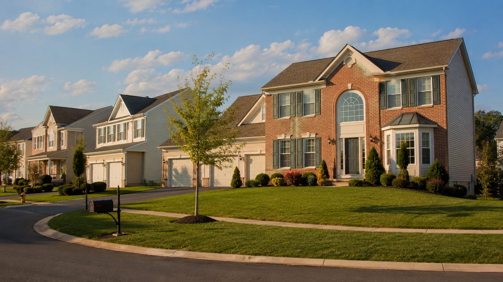 A 1990s brick-and-vinyl colonial home with palladian transom window and three-car garage in a Doylestown subdivision