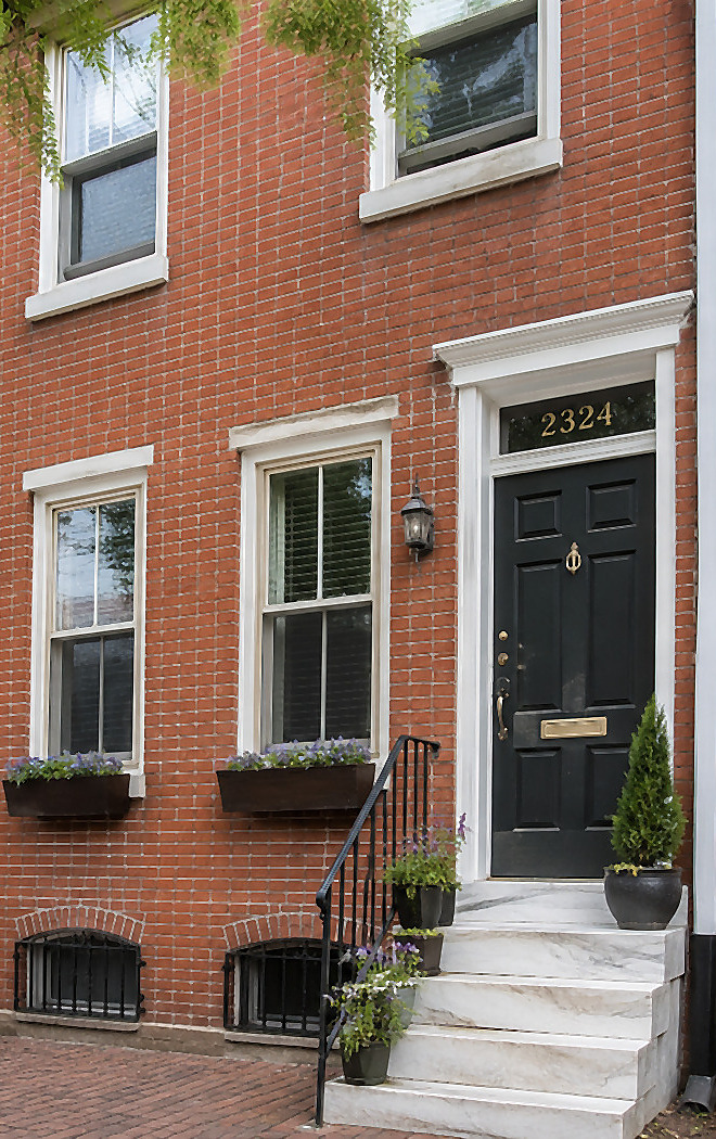 A classic Philadelphia brick row home with marble steps and a dark painted front door